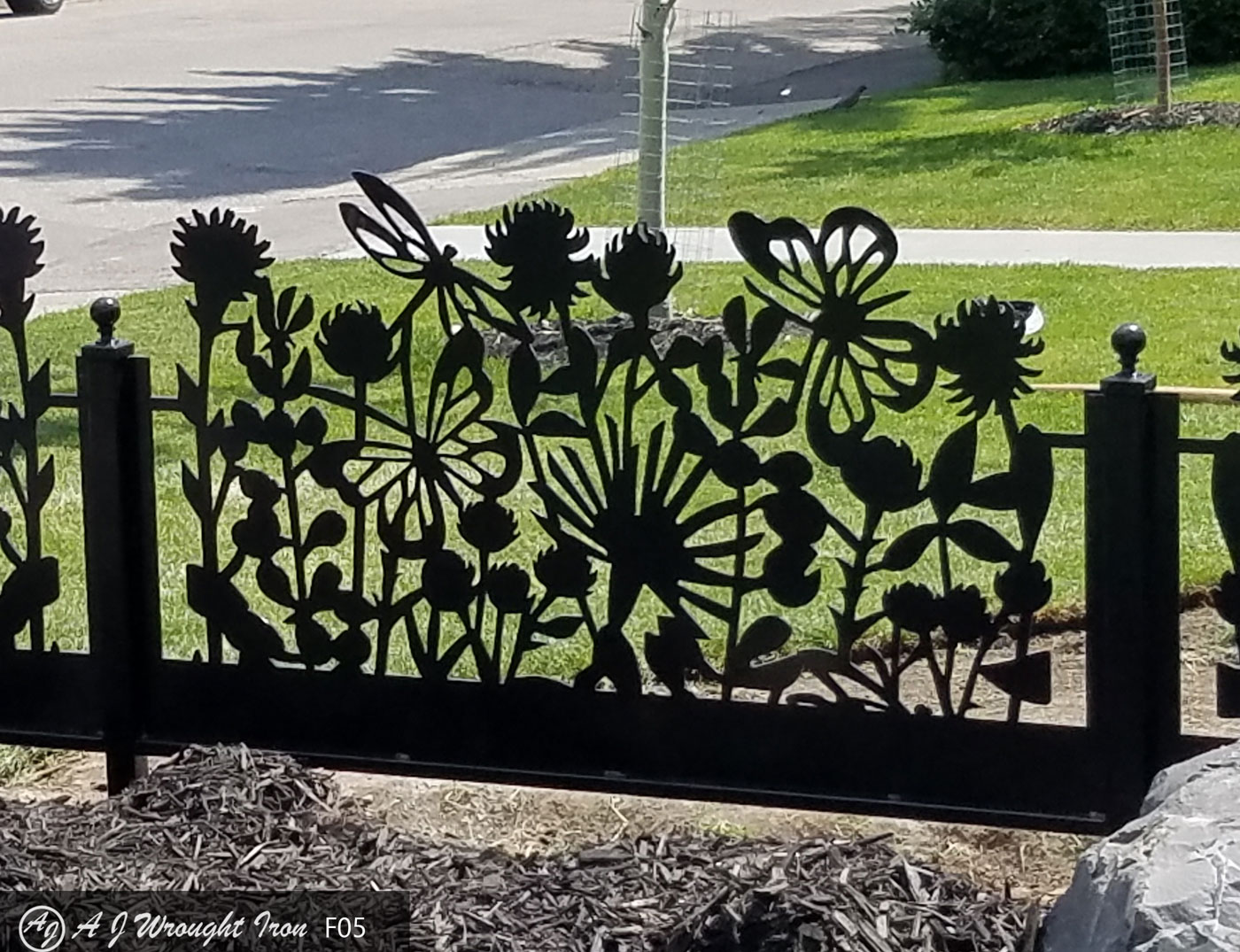 closeup of laser cut metal garden fence with flower pattern