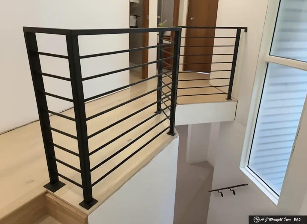black modern railing with horizontal spindles above interior staircase.