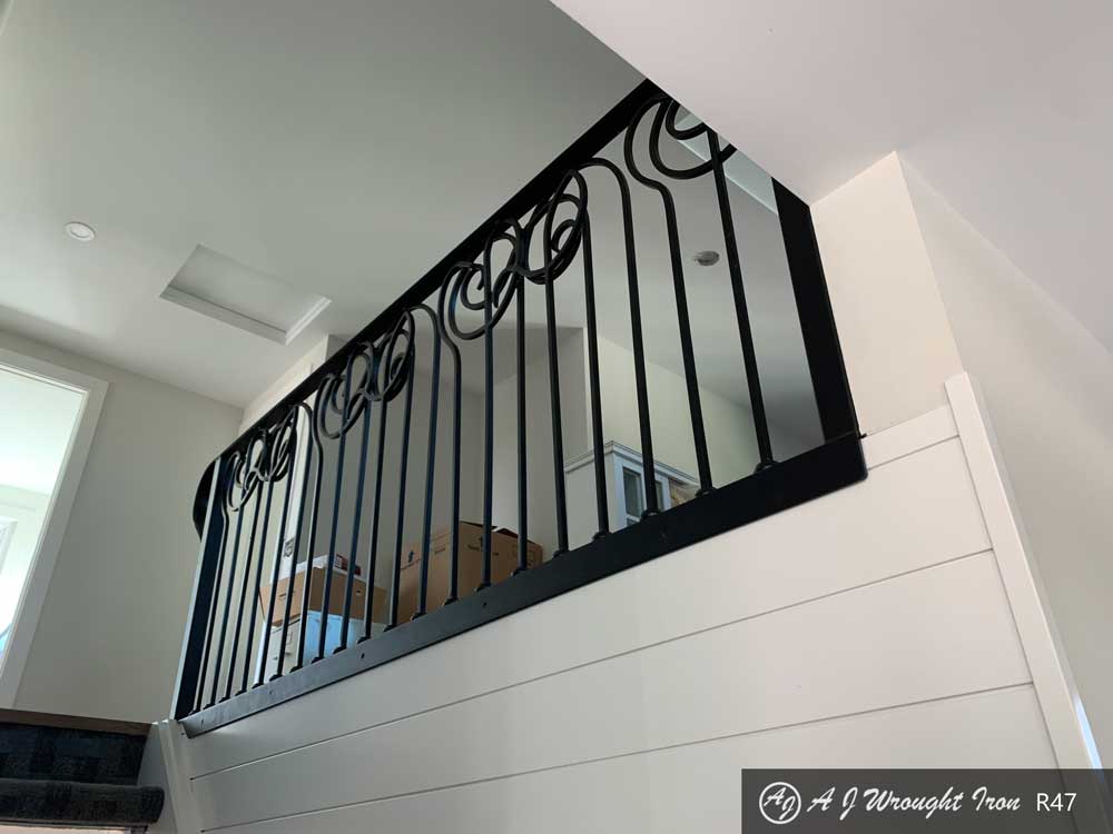 overlapping curled spindles on custom forged railing